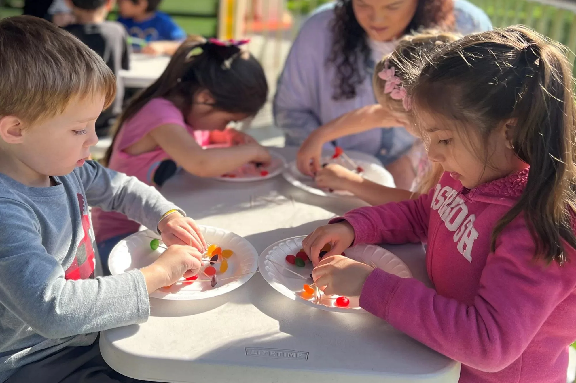 Preschool children conducting hands-on outdoor science experiments and exploring nature ecosystems at Newport Ave Preschool
