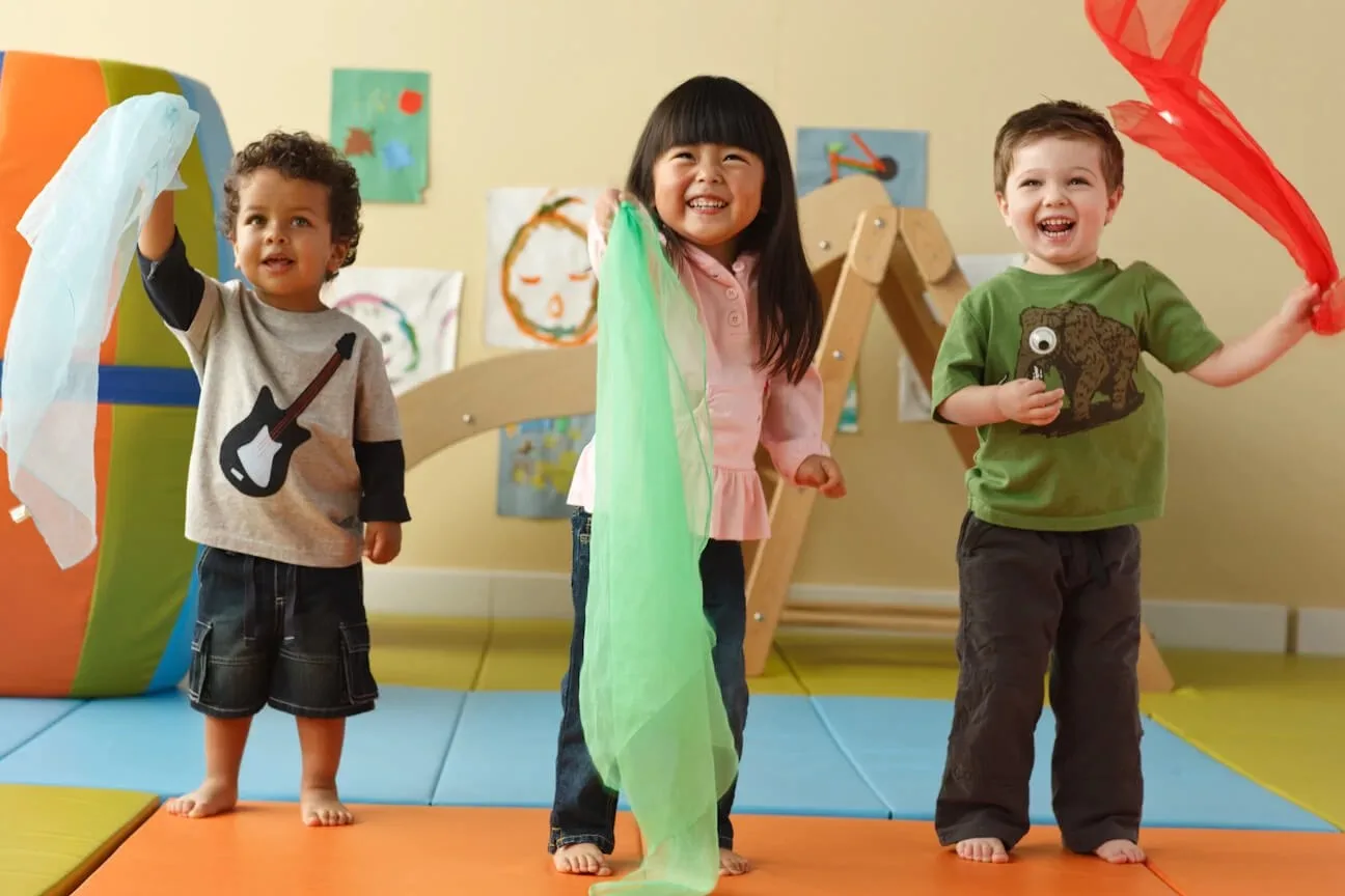 Children engaged in a group physical fitness and dance enrichment activity outdoors at Newport Ave Preschool