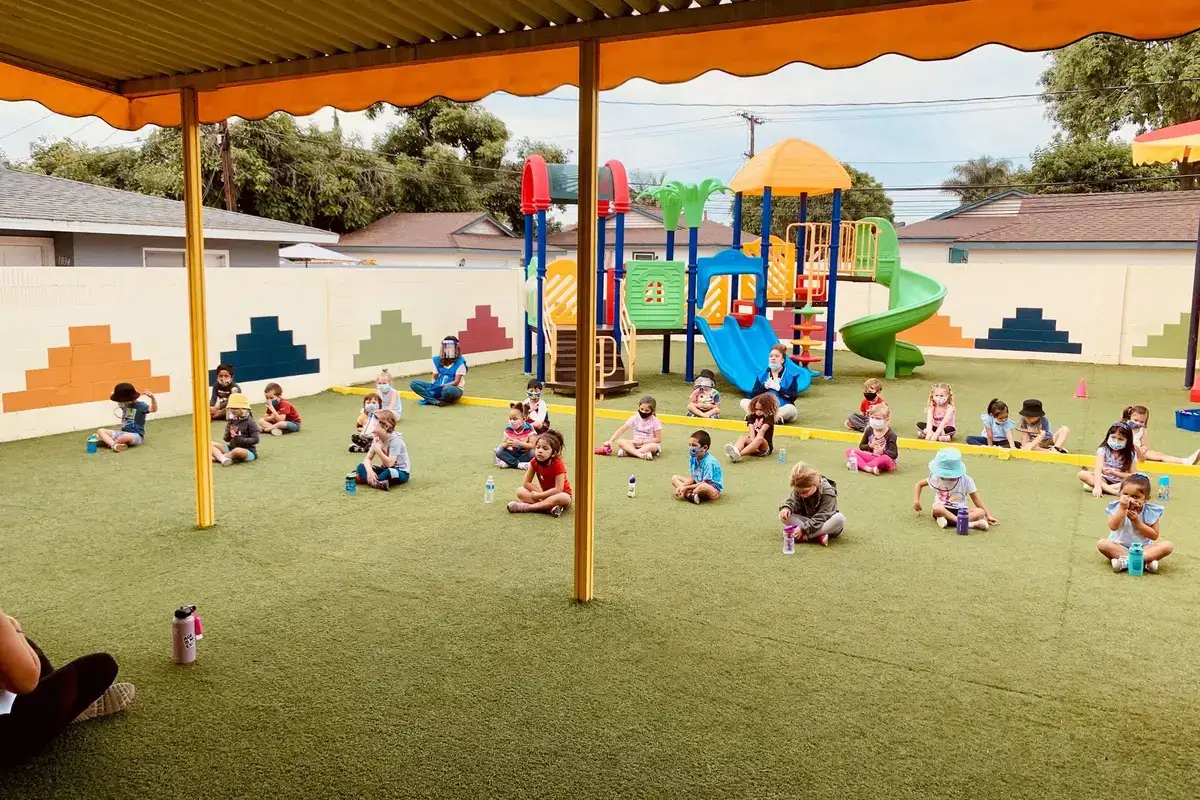 Children doing a yoga session outdoors with a lecturer at Newport Ave Preschool's mindfulness and yoga enrichment class