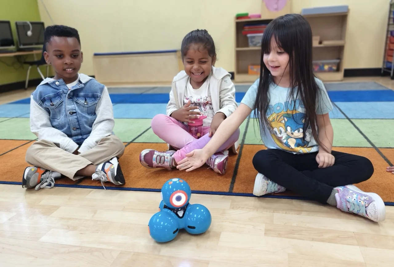 Transitional Kindergarten child engaged in a STEM activity with an electronic toy in a Montessori-inspired classroom at Newport Ave Preschool