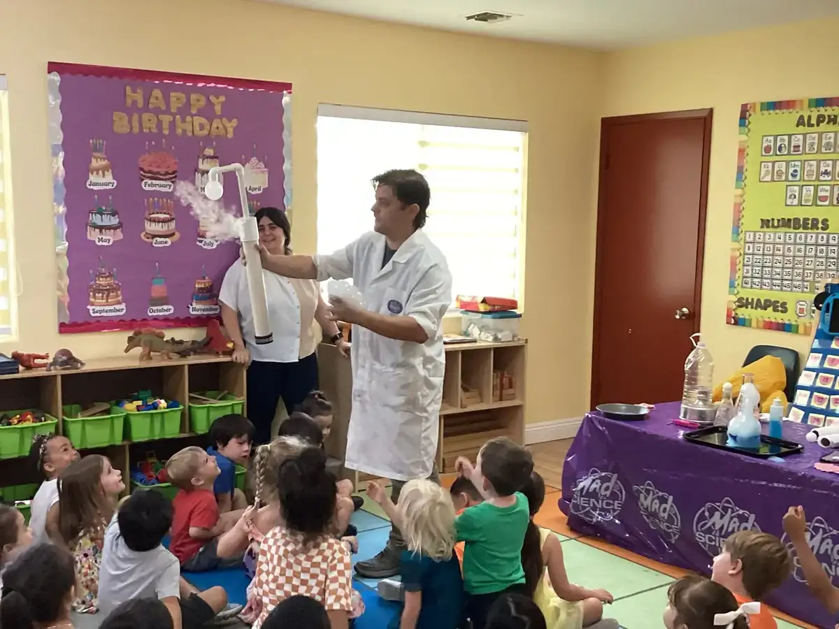 Children doing a science experiment with a lecturer at Newport Ave Preschool's STEAM enrichment program