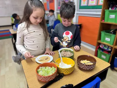 Preschool children enjoying a summer cooking and culinary activity as part of hands-on group learning at Newport Ave Preschool